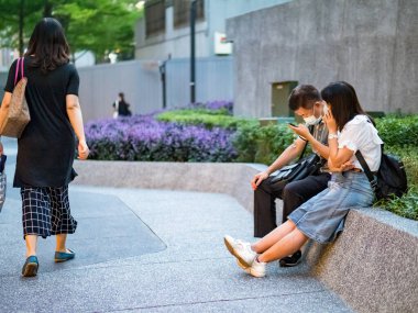 TAIPEI, TAIWAN - 19 Mayıs 2021 tarihinde Tayvan 'ın Taipei kentinde cerrahi maske takan yolcular. 165.096.424 doğrulanmış COVID-19 vakası yaşandı..