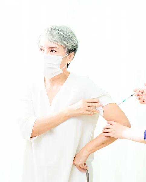 高齢のアジアの女性は 抗体を受け取るために医師によるコロナウイルスワクチンの注射を受け 人口を免疫化 — ストック写真