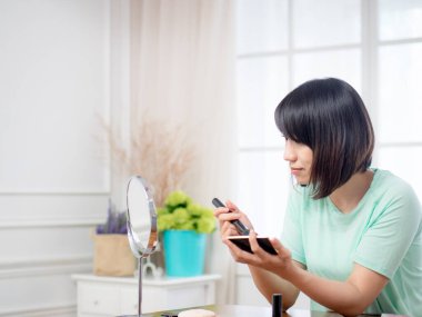 Makyaj malzemeleri olan genç bir kız.