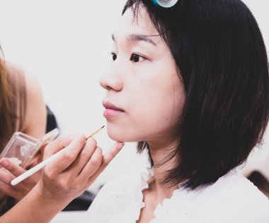 Makyaj malzemeleri olan genç bir kız.