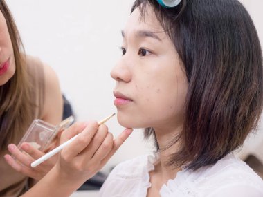 Makyaj malzemeleri olan genç bir kız.