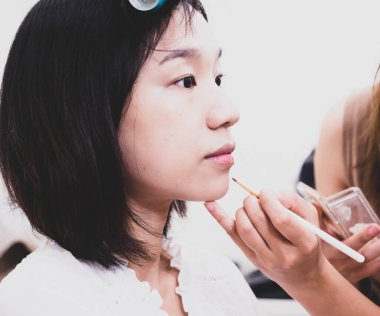 Makyaj malzemeleri olan genç bir kız.