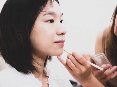 Makyaj malzemeleri olan genç bir kız.