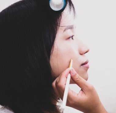 Makyaj malzemeleri olan genç bir kız.