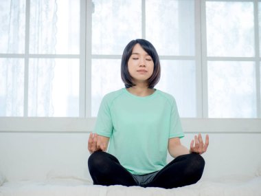 Yoga yapan, gülümseyen çekici bir Yogi kadını.