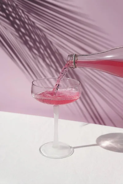 Рожеве Шампанське Напій Столі Сонячними Тінями Рожевому Тлі Пальмовим Листям — стокове фото