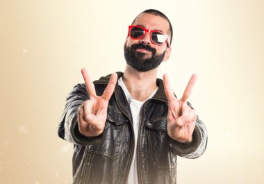 Yukarı başparmak ile bir deri ceket giyen adam