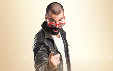 Öne doğru işaret eden bir deri ceket giyen adam