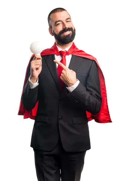 Super hrdina podnikatel drží žárovku — Stock fotografie