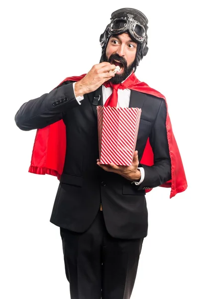 Super eroe uomo d'affari mangiare popcorn — Foto Stock