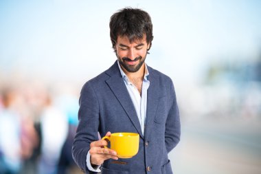 bir fincan kahve beyaz arka plan üzerinde tutan adam 