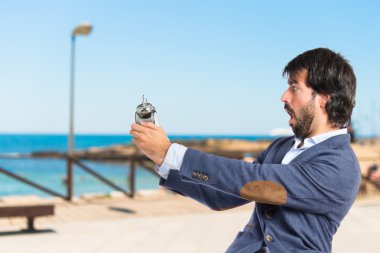 beyaz zemin üzerinde bir saat tutan adam