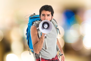 Beyaz arka plan üzerinde megafon tarafından bağırarak backpacker