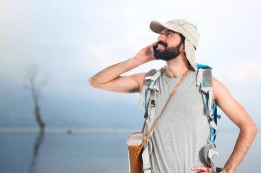 Beyaz arka plan üzerinde konuşmak için telefon backpacker