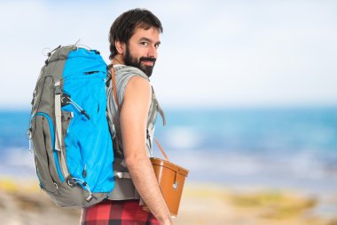 Genç backpacker beyaz arka plan üzerinde yürüme