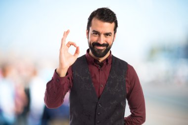 Ok işareti yapma yelek giyen adam 