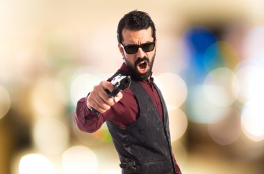 Bir tabanca ile ateş yelek giyen adam 