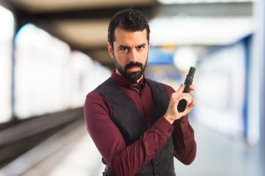 Bir tabanca ile yelek giyen adam 