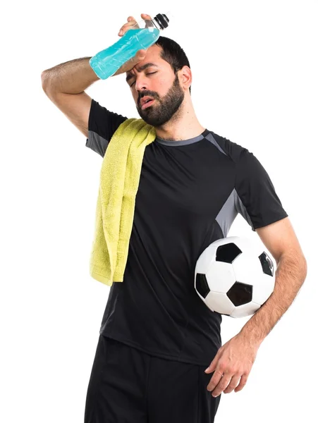 Уставший футболист держит газировку — стоковое фото