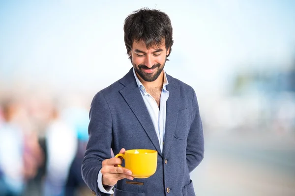 Homem segurando uma xícara de café sobre fundo branco — Fotografia de Stock