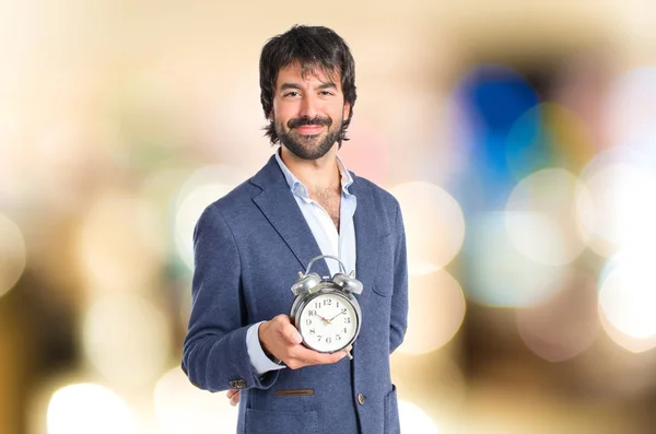 Empresario sosteniendo un reloj sobre fondo blanco — Foto de Stock