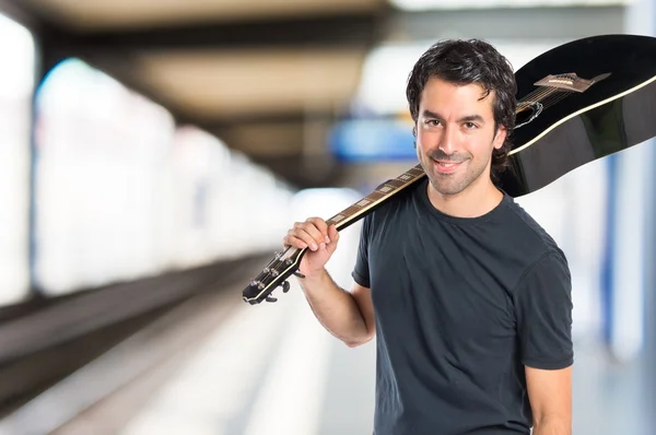 Knappe man met gitaar op witte achtergrond — Stockfoto