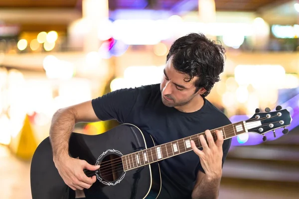 Pohledný muž s kytarou na bílém pozadí — Stock fotografie