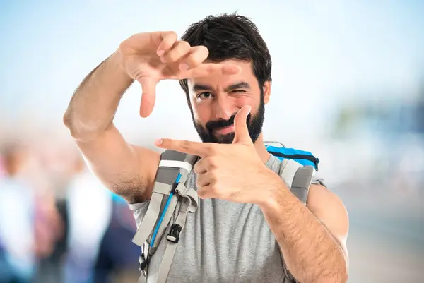 Backpacker konzentriert sich mit seinen Fingern auf weißem Hintergrund — Stockfoto