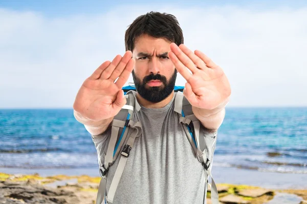 Backpacker att göra stoppskylt över vit bakgrund — Stockfoto