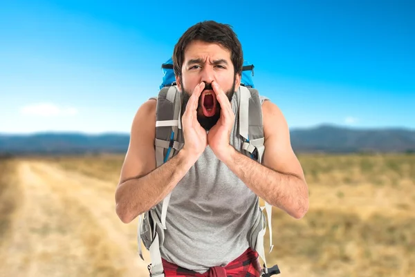 Backpacker shouting over isolated white background — Stock Photo, Image