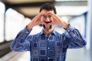 Vintage genç adam elleriyle bir kalp yapma 