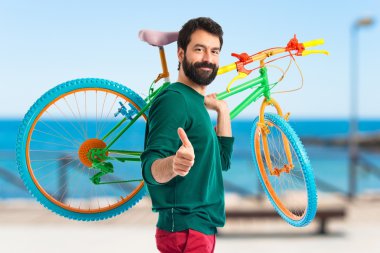 Yenilikçi bir bisiklet tutarak yukarı başparmak