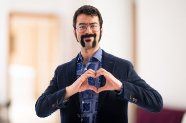 Vintage genç adam elleriyle bir kalp yapma 