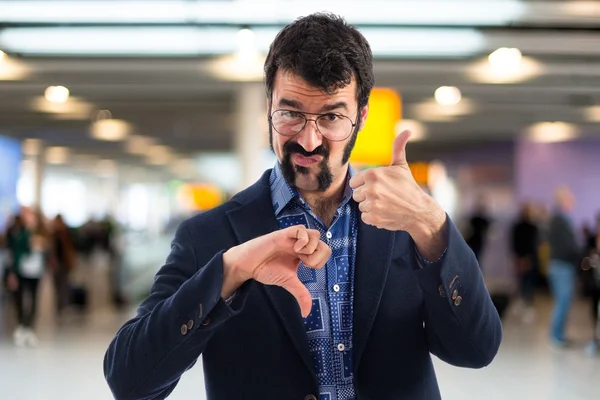 Junger Mann macht gutes-schlechtes Zeichen — Stockfoto