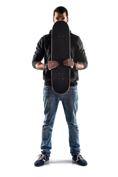 Человек прячется за скейтбордом — стоковое фото