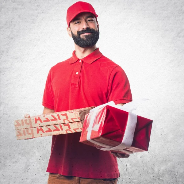 Entrega de pizza homem segurando um presente — Fotografia de Stock