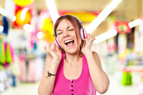 Chica joven escuchando música sobre fondo blanco —  Fotos de Stock