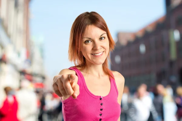 Junges Mädchen zeigt auf weißen Hintergrund — Stockfoto