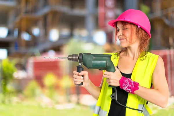 Werknemer vrouw met boor op witte achtergrond — Stockfoto