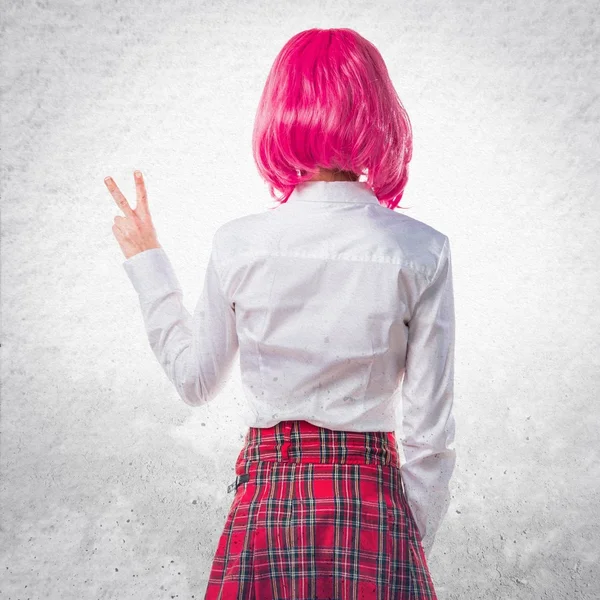 Menina com cabelo rosa fazendo gesto de vitória — Fotografia de Stock