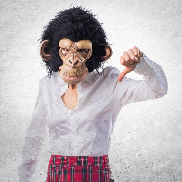 Dívka s maskou opice dělá špatný signál — Stock fotografie