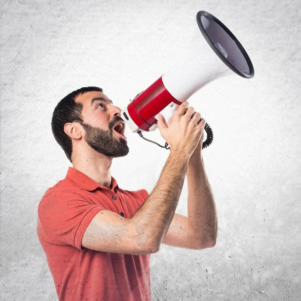 Handsome man shouting by megaphone — Stock Photo, Image