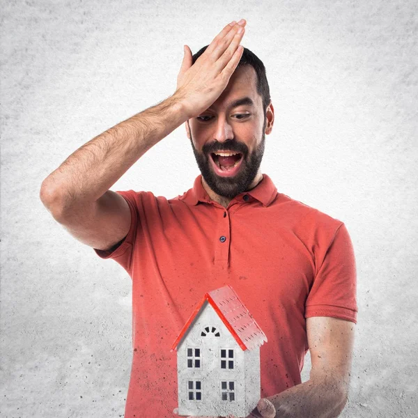 Hombre guapo sosteniendo una casita — Foto de Stock