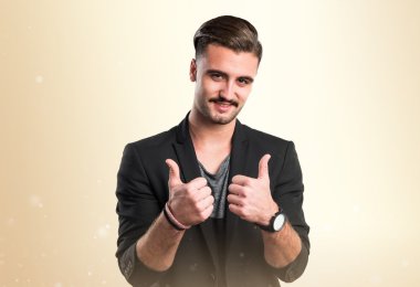 Başparmağı havada yakışıklı bir adam.