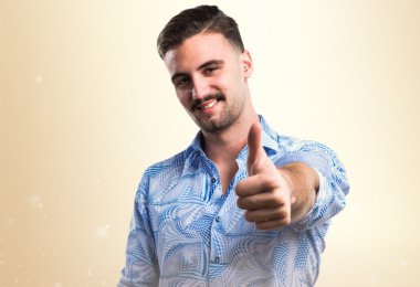 Başparmağı havada yakışıklı bir adam.