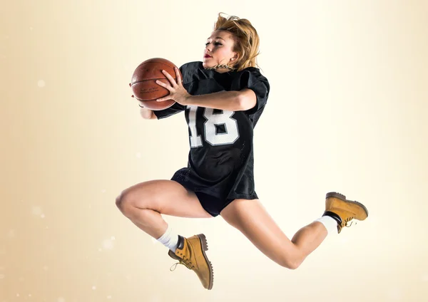 Mujer saltando y jugando baloncesto — Foto de Stock