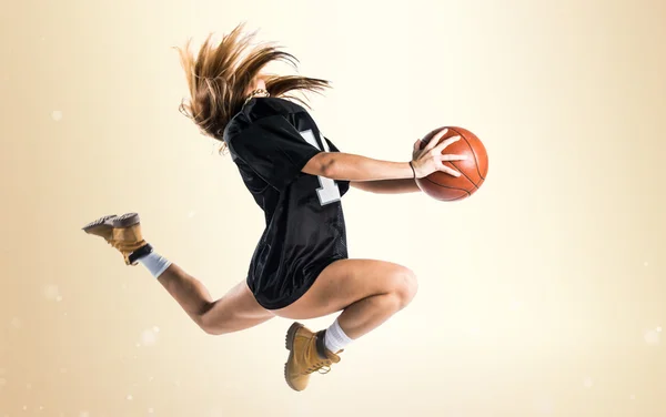 Mulher pulando e jogando basquete — Fotografia de Stock