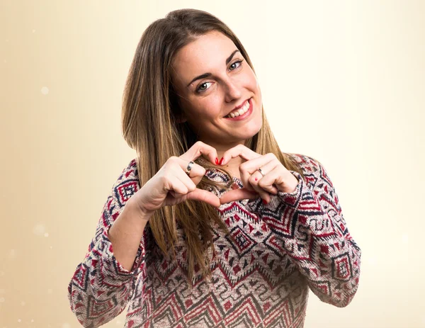 Blonde woman making a heart with her hands — Stock Photo, Image