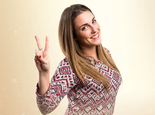 Blonde woman doing victory gesture — Stock Photo, Image