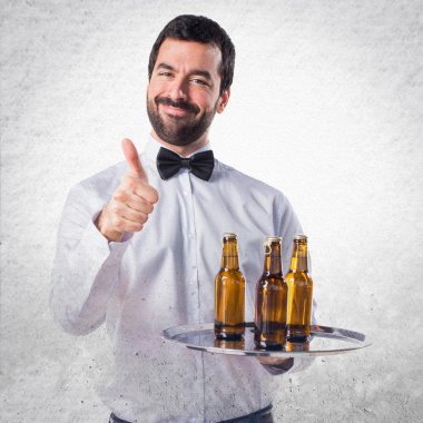 Garson bira şişeleri başparmak ile tepsi ile